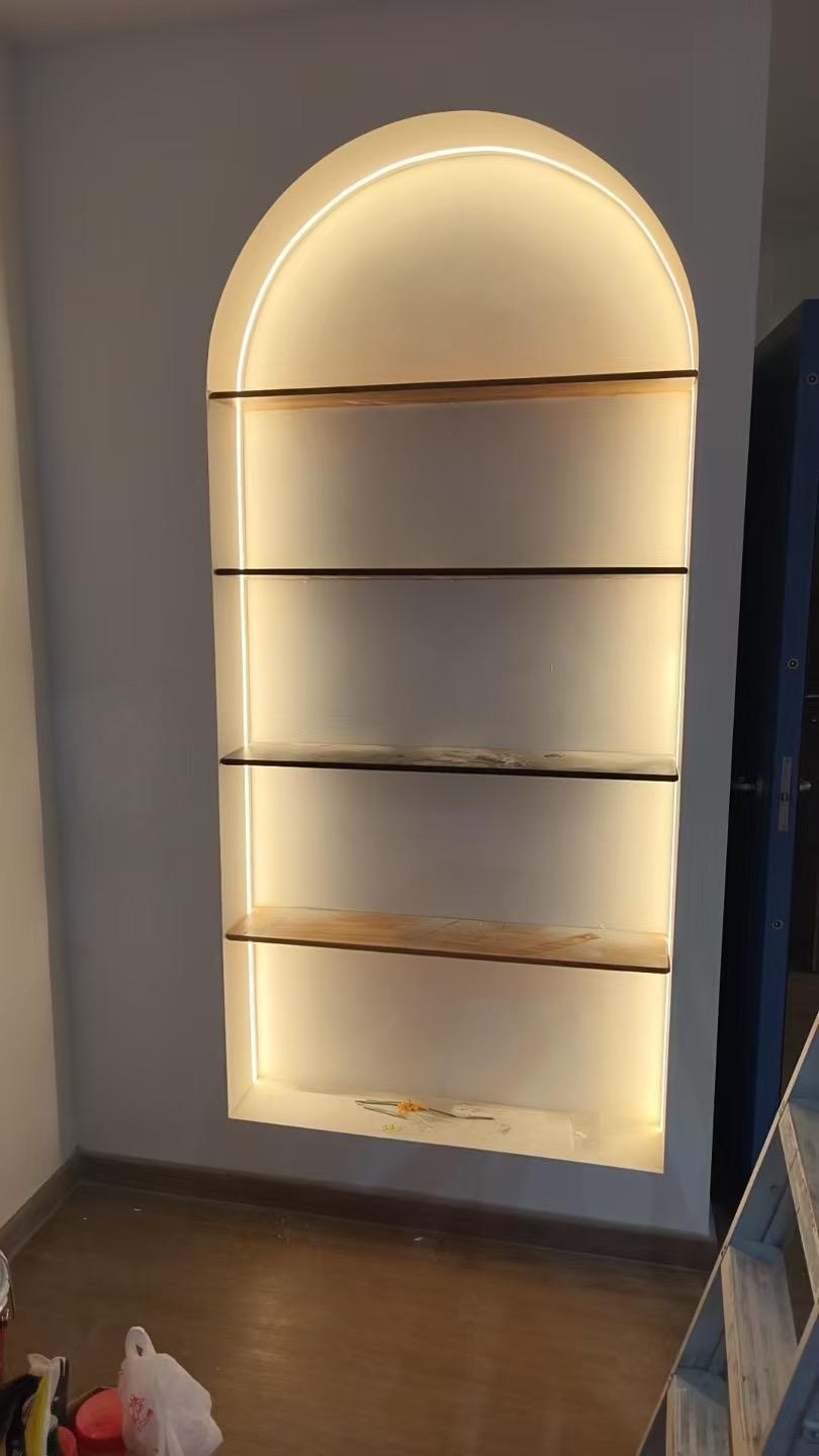 Arched wall display shelf with integrated lighting installed by The Good Guys Singapore.