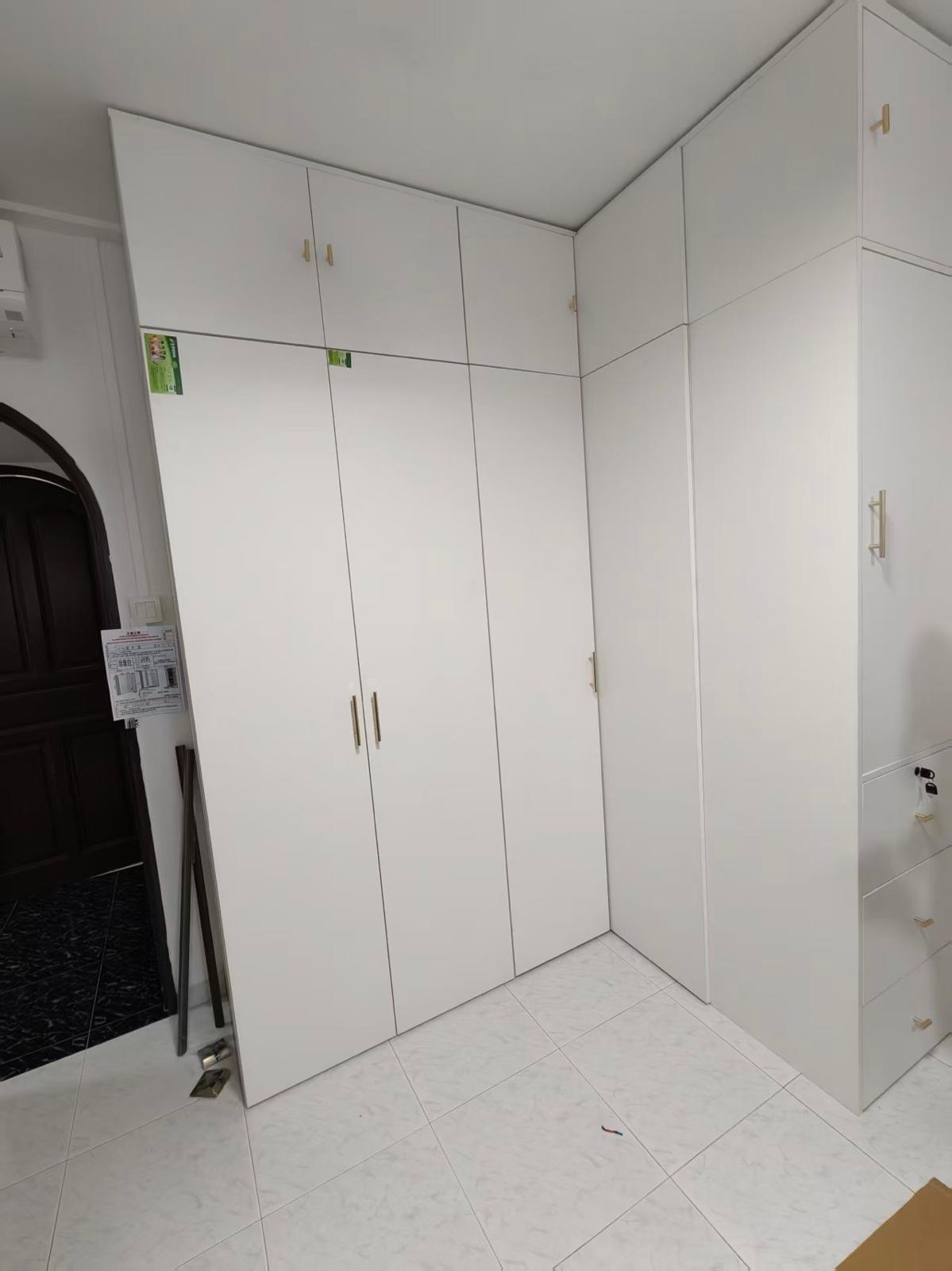 L-shaped full-height white wardrobe with top cabinets assembled by The Good Guys Singapore.